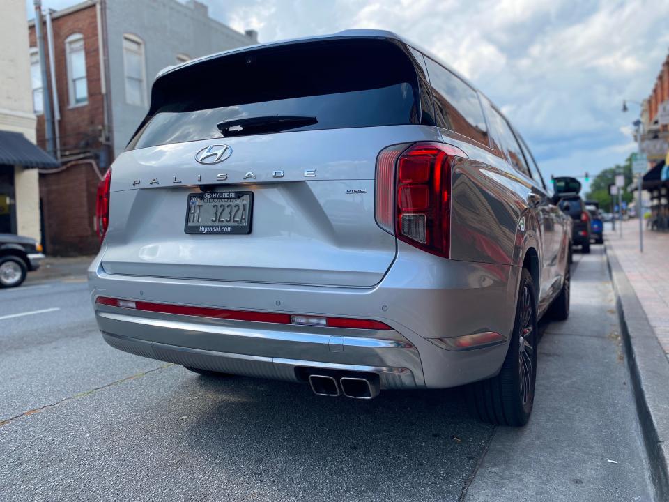 The rear end of a silver Hyundai Palisade SUV parked on a street.