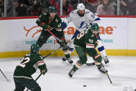 Minnesota Wild center Frederick Gaudreau, right, Tampa Bay Lightning defenseman Zach Bogosian (24) and Wild's Victor Rask (49) battle for control of the puck during the first period of an NHL hockey game Sunday, Nov. 28, 2021, in St. Paul, Minn. (AP Photo/Craig Lassig)