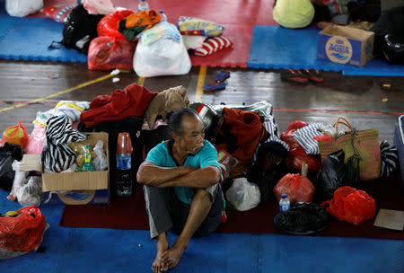 A man rests at a temporary evacuation center for people living near Mount Agung, a volcano on the highest alert level, inside a sports arena in Klungkung, on the resort island of Bali, Indonesia, September 24, 2017. REUTERS/Darren Whiteside