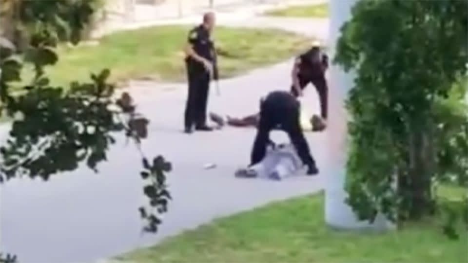 An officer shot the unarmed black man in the leg while he was lying on the road trying to calm his patient. Photo: Hilton Napoleon II