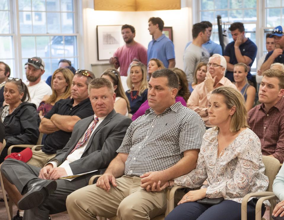 Former Portsmouth High School football coach Ryan Moniz, center, listens during a School Committee meeting in 2018.