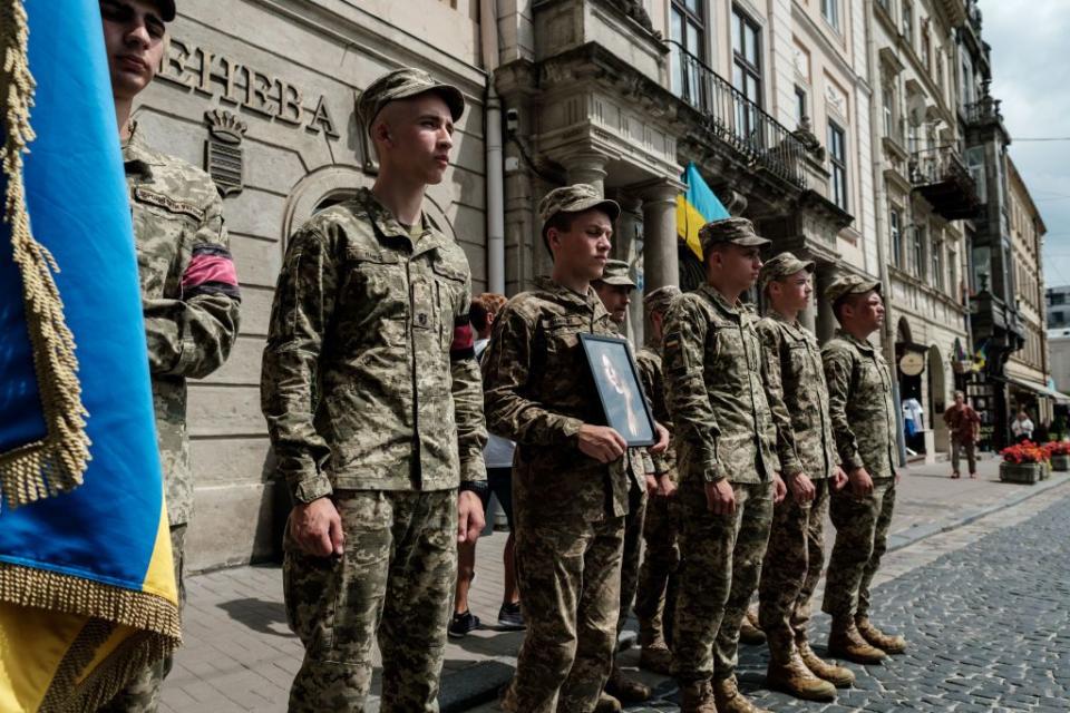 Ukrainian soldiers hold a portrait of the Victoria Amelina in her honor during her funeral service on July 5, 2023, in Lviv, Ukraine. (Photo by Les Kasyanov/Global Images Ukraine via Getty Images)