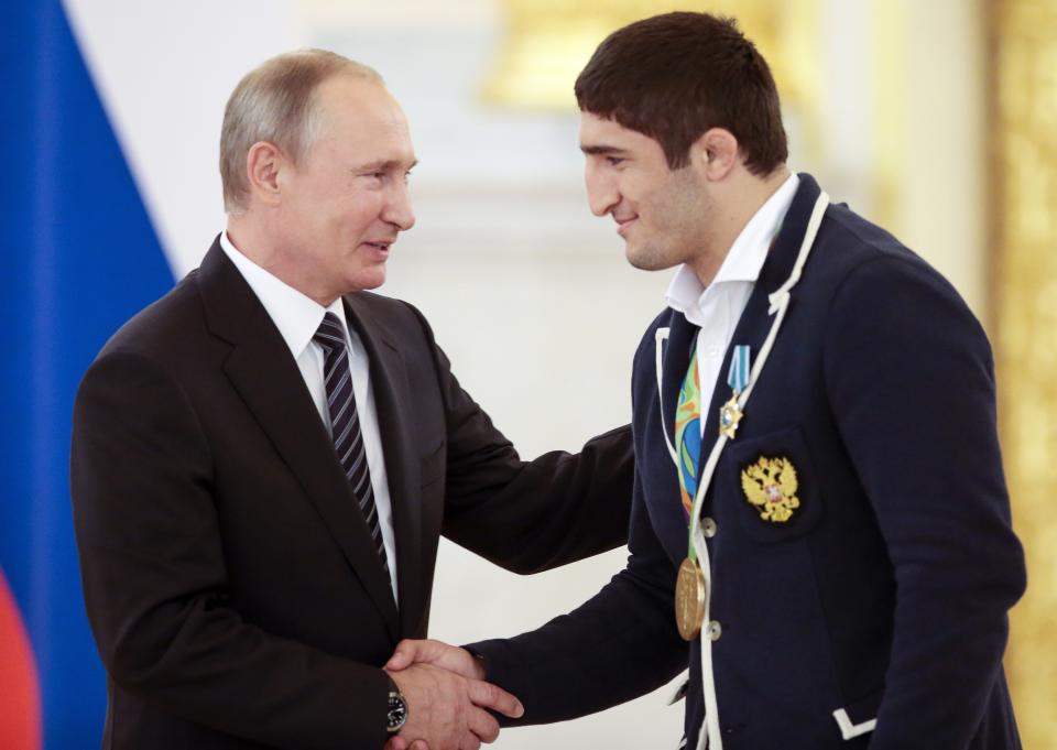 FILE - Russian President Vladimir Putin, left, shakes hands with Russia's Abdulrashid Sadulaev, gold medalist for the men's 86-kg freestyle wrestling competition, during an awarding ceremony for Russia's Olympians in Moscow's Kremlin in Moscow, Russia, Thursday, Aug. 25, 2016. (AP Photo/Ivan Sekretarev, File)