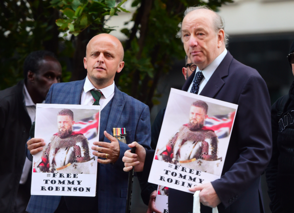 <em>Robinson supporters held placards as the former EDL leader arrived for his court appearance (PA)</em>