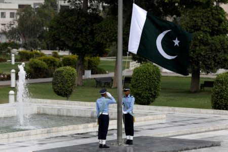 A member of the Pakistan air force salutes as the national flag is raised at the mausoleum of Muhammad Ali Jinnah during Defence Day ceremonies, or Pakistan's Memorial Day, in Karachi, Pakistan September 6, 2018. REUTERS/Akhtar Soomro