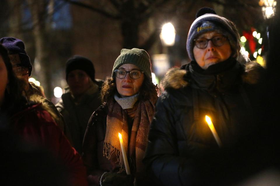 Cross Roads House held a vigil in downtown Portsmouth on Thursday, Dec. 21, 2023 to mark Homeless Persons' Memorial Day. Former executive director of Cross Roads House Martha Stone, center, attends the event with about 40 other people.