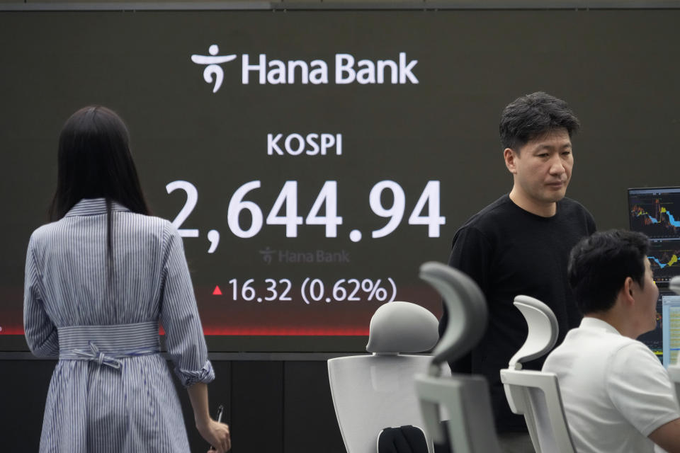 Currency traders watch monitors near the screen showing the Korea Composite Stock Price Index (KOSPI) at the foreign exchange dealing room of the KEB Hana Bank headquarters in Seoul, South Korea, Friday, April 26, 2024. Asian shares mostly rose Friday despite worries about the economic outlook and inflation in the U.S. and the rest of the world. (AP Photo/Ahn Young-joon)