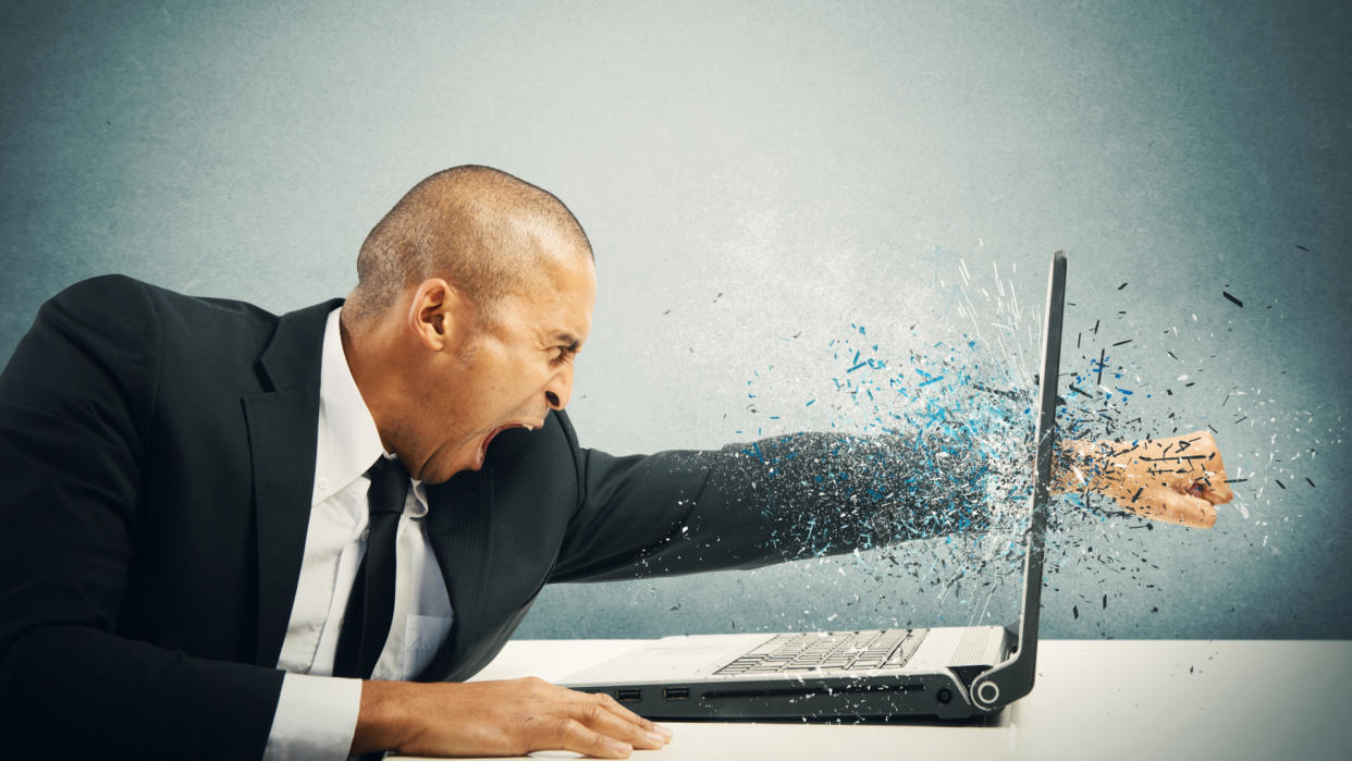  An angry person punching their laptop. 