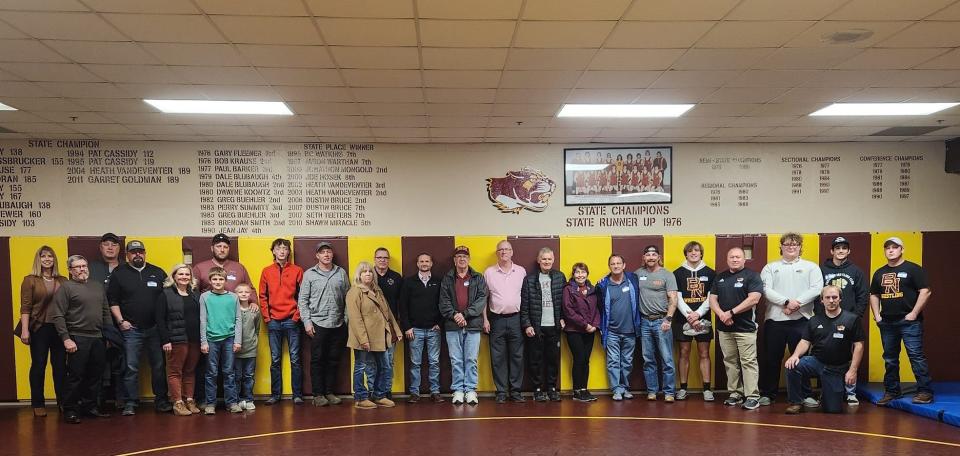 Members of the inaugural class inducted to the Cougar Legacy Club pose in the recently repainted wrestling room at Bloomington North.