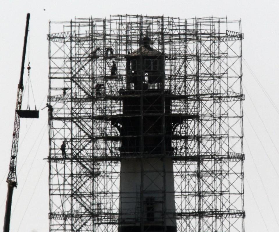 Getting ready: Workers remove sheet metal and wood from the Bodie Island lighthouse, which is under renovation, as Hurricane Earl approaches the Outer Banks Wednesday. Forecasters say even an offshore storm track would bring wind gusts of up to 80 mph to the coast.