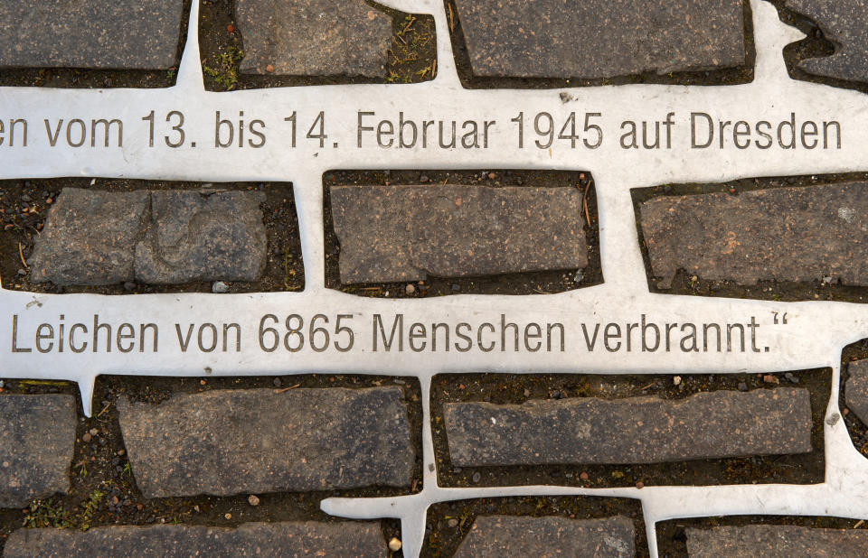An inscript is fixed at the Altmarkt (Old Market) ground in Dresden, Germany, Tuesday, Feb. 11, 2020 two days before the 75th anniversary of the Allied bombing of Dresden during WWII. Part of the inscript reads: '13 until 14 February 1945 - 6865 bodies were cremated here'. After the bombardment on Dresden of 13 and 14 February 1945, the Altmarkt was one of the two locations where bodies of casualties were cremated on large pyres. British and U.S. bombers on Feb. 13-14, 1945 destroyed Dresden's centuries-old baroque city center. (AP Photo/Jens Meyer)
