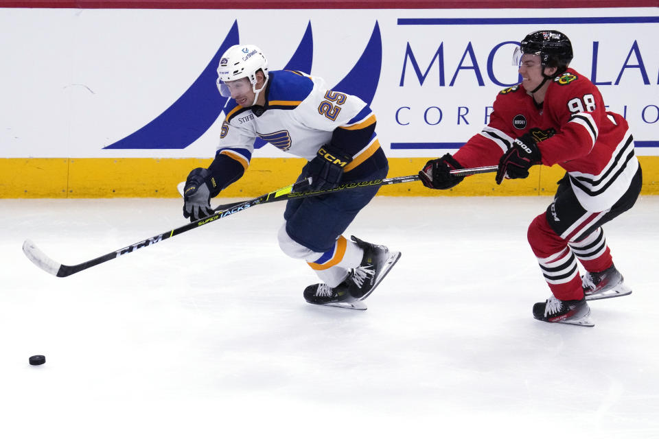 St. Louis Blues center Jordan Kyrou, left, chases the puck past Chicago Blackhawks center Connor Bedard during the second period of an NHL hockey game in Chicago, Sunday, Nov. 26, 2023. (AP Photo/Nam Y. Huh)