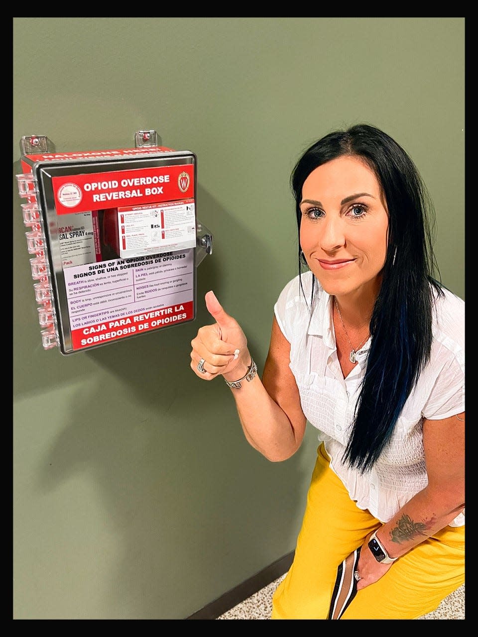 Erin Rachwal, who lost her son to fentanyl poisoning in 2021, stands next to a Narcan box, which have been installed across the UW-Milwaukee campus.