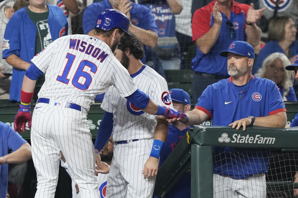 Chicago Cubs manager David Ross, right, greets Patrick Wisdom at the dugout after Wisdom's home run off Milwaukee Brewers starting pitcher Wade Miley during the fifth inning of a baseball game Monday, Aug. 28, 2023, in Chicago. (AP Photo/Charles Rex Arbogast)