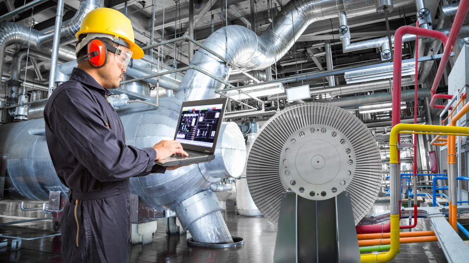 Engineer using laptop computer for maintenance in thermal power plant industrail.