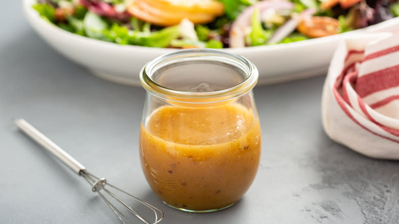 Creamy vinaigrette with salad backdrop