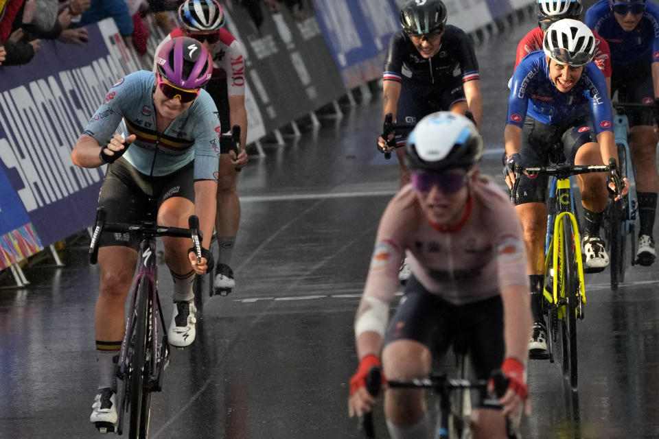 Annemiek van Vleuten of Netherlands, third right, passes the finish line to win the elite women's road race ahead of Belgium's Lotte Kopecky, left, and Italy's Silvia Persico, second right, at the world road cycling championships in Wollongong, Australia, Saturday, Sept. 24, 2022. (AP Photo/Rick Rycroft)