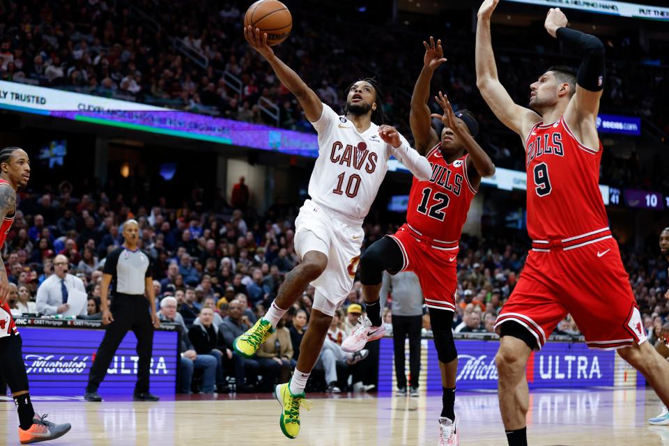 Cleveland Cavaliers guard Darius Garland (10) shoots against Chicago Bulls center Nikola Vucevic (9) and guard Ayo Dosunmu (12) during the second half of an NBA basketball game, Saturday, Feb. 11, 2023, in Cleveland. (AP Photo/Ron Schwane)