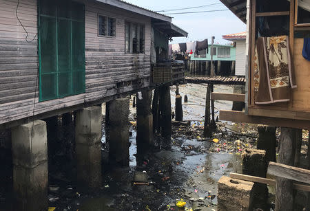 Rubbish can be seen below stilt houses and wooden paths in the village of Hanuabada, located in Port Moresby Harbour in Papua New Guinea, November 19, 2018. REUTERS/Phillip Wen