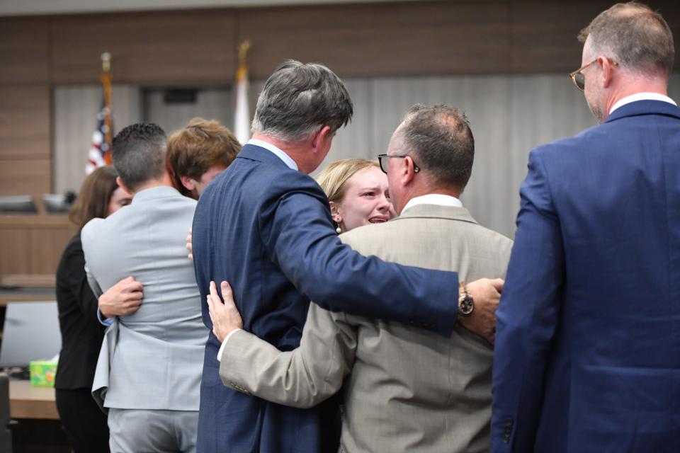 The Kowalski family, Jack, in tan jacket, Maya, center, and Kyle, in back, hug their team of attorneys after a jury awarded them more than $200 million on Thursday, Nov. 9, 2023. The Kowalski family sued Johns Hopkins All Children's Hospital for false imprisonment, negligent infliction of emotional distress, medical negligence, battery, and other claims more than a year after the family matriarch, Beata Kowalski, took her life following allegations she was abusing her daughter, Maya Kowalski.