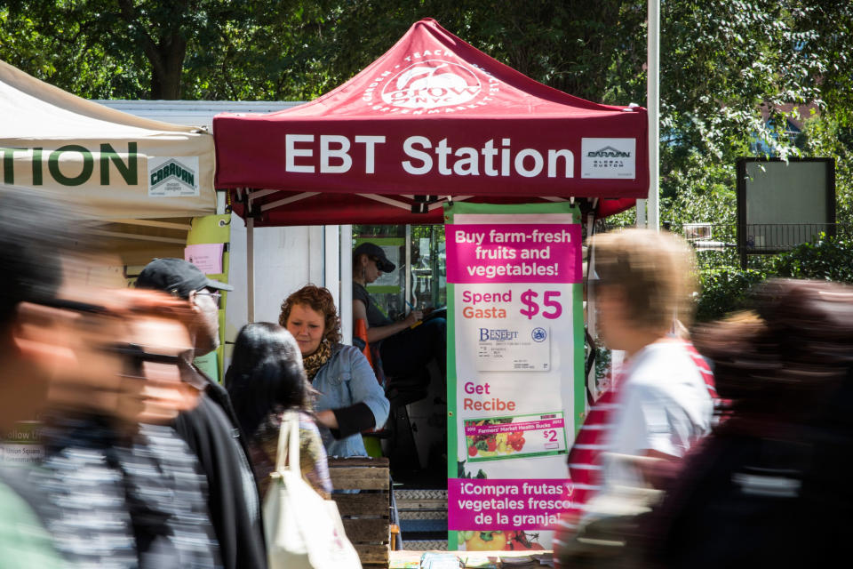 People walk past an EBT station in the GrowNYC Greenmarket (Andrew Burton / Getty Images file)