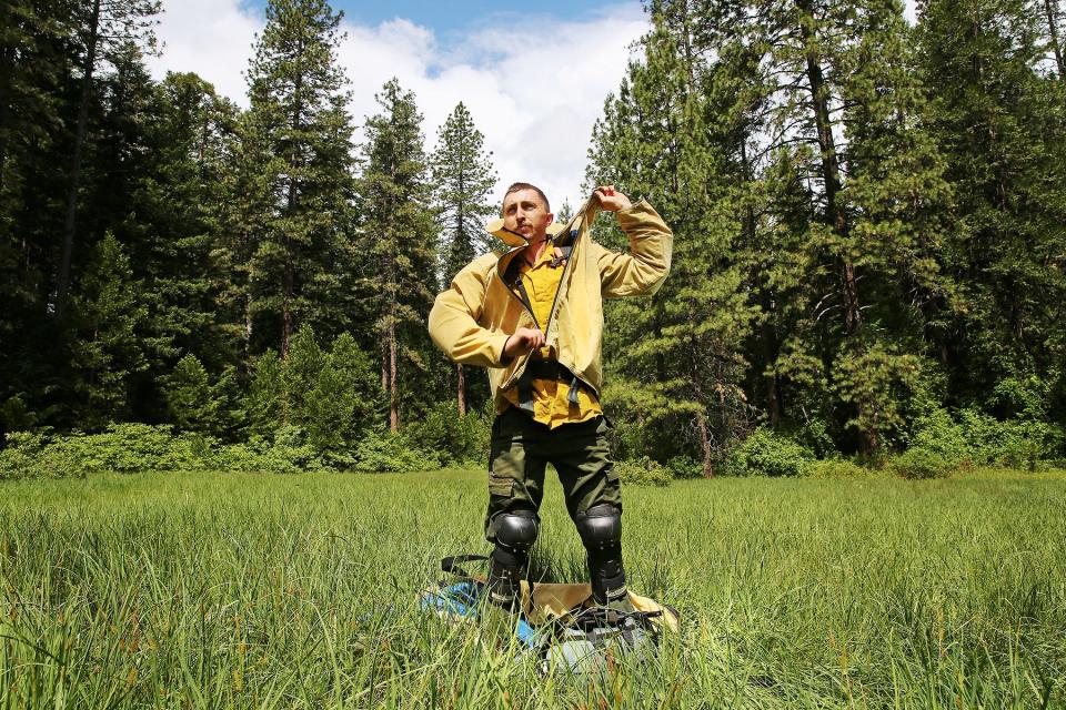 A smokejumper unzips from his Kevlar landing suit.