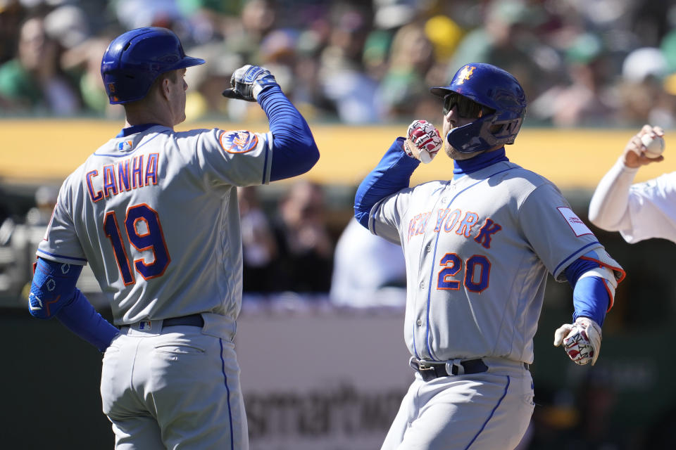 New York Mets' Pete Alonso (20) is congratulated by Mark Canha (19) after hitting a home run against the Oakland Athletics during the ninth inning of a baseball game in Oakland, Calif., Sunday, April 16, 2023. (AP Photo/Jeff Chiu)
