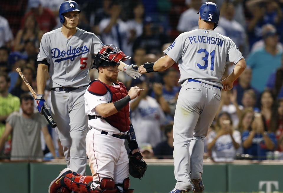 Los Angeles Dodgers' Joc Pederson (31) celebrates with Corey Seager (5) behind Boston Red Sox's Christian Vazquez after scoring on a bases-loaded walk during the 12th inning of a baseball game in Boston, Monday, July 15, 2019. (AP Photo/Michael Dwyer)