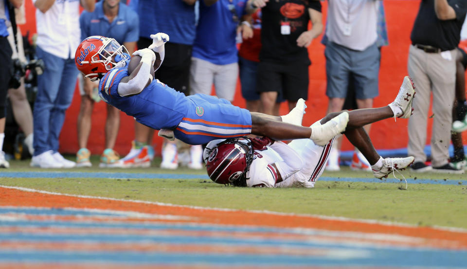 Florida running back Trevor Etienne (7) scores an 85-yard touchdown past South Carolina defensive back Cam Smith (9) in the first half of an NCAA college football game, Saturday, Nov. 12, 2022, in Gainesville, Fla. (AP Photo/Matt Stamey)