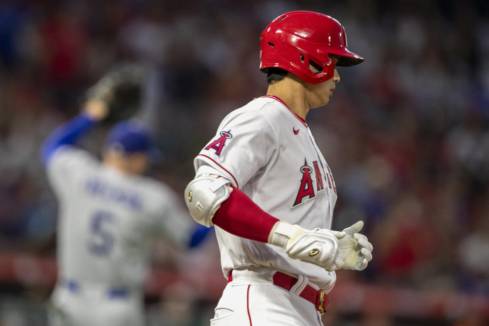 Los Angeles Angels designated hitter Shohei Ohtani reaches first on an error by Los Angeles Dodgers first baseman Freddie Freeman, left, during the third inning of a baseball game in Anaheim, Calif., Saturday, July 16, 2022. (AP Photo/Alex Gallardo)