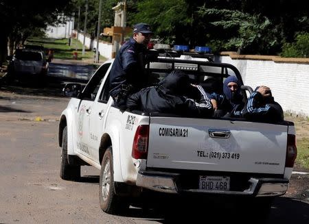 Detained fans of Boca Juniors football club depart in a police vehicle at the headquarters of the Special Operations Forces of the Paraguayan Police in Asuncion, Paraguay, April 29, 2016. REUTERS/Jorge Adorno