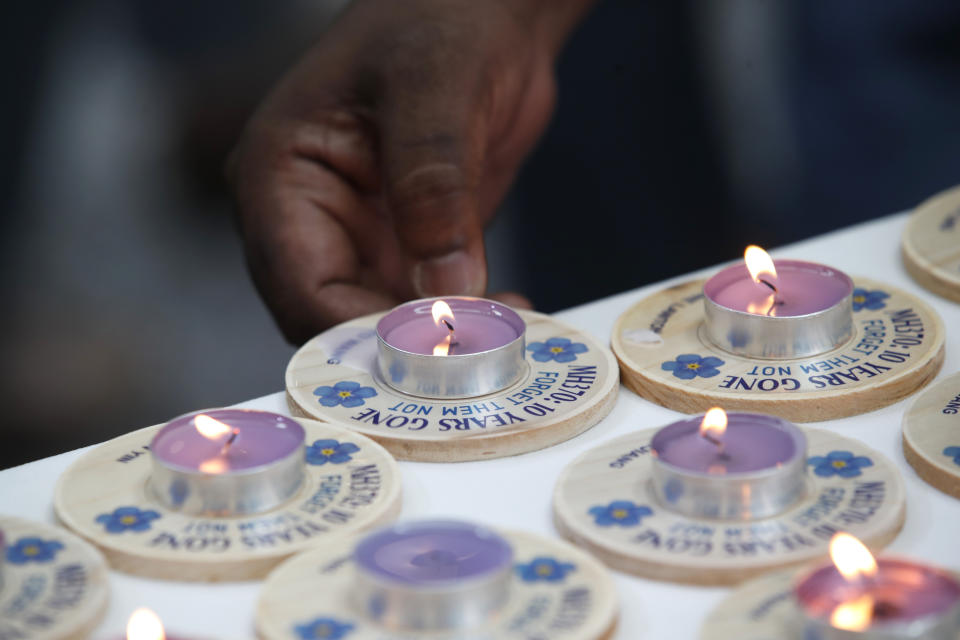 A family member of passengers on board of the missing Malaysia Airlines Flight 370 places a candle during the tenth annual remembrance event at a shopping mall, in Subang Jaya, on the outskirts of Kuala Lumpur, Malaysia, Sunday, March 3, 2024. Ten years ago, a Malaysia Airlines Flight 370, had disappeared March 8, 2014 while en route from Kuala Lumpur to Beijing with over 200 people on board. (AP Photo/FL Wong)