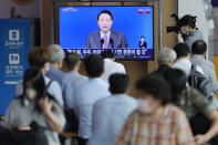 People watch a TV screen showing the live broadcast of South Korean President Yoon Suk Yeol's press conference, at the Seoul Railway Station in Seoul, South Korea, Wednesday, Aug. 17, 2022. Yoon said Wednesday his government has no plans to pursue its own nuclear deterrent in the face of growing North Korean nuclear threats, as he urged the North to return to dialogue aimed at exchanging denuclearization steps for economic benefits. (AP Photo/Lee Jin-man)