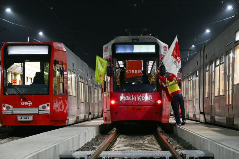 Strikers attach Verdi flags to a streetcar. Verdi has called on employees of municipal transport companies in North Rhine-Westphalia to strike on Tuesday and Wednesday. Federico Gambarini/dpa