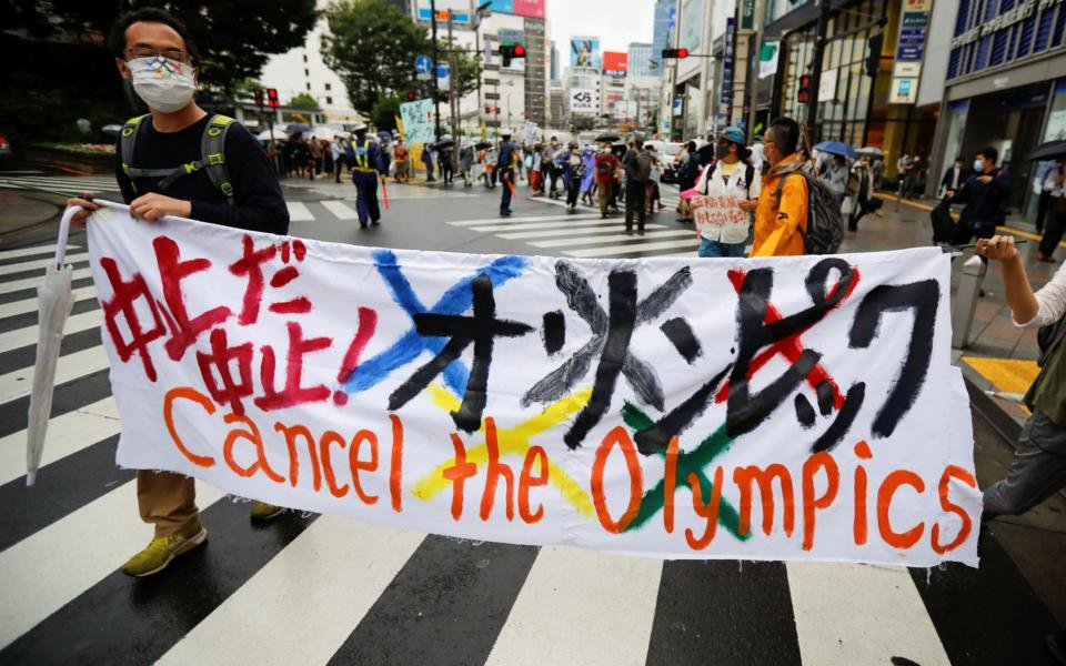 Anti-Olympics group's members display a banner during their protest march, amid the coronavirus outbreak, in Tokyo - Reuters