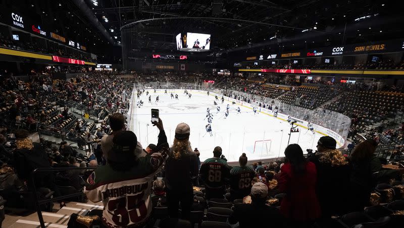 FILE - Fans watch as players warm up prior to the Arizona Coyotes’ home-opening NHL hockey game against the Winnipeg Jets at the 5,000-seat Mullett Arena in Tempe, Ariz., Oct. 28, 2022. The Coyotes say owner Alex Meruelo has executed a letter of intent to buy a piece of land for a potential arena in Mesa, Arizona. The move comes months after voters in Tempe rejected a referendum to construct an arena there for the NHL club. 