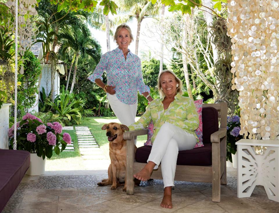 Liza Pulitzer (standing) and Minnie Pulitzer, with Liza's dog, Cocoa, are seen at Liza's Palm Beach home. The sisters recently worked with the Lilly Pulitzer brand on a 65th anniversary capsule collection, Barefoot in Paradise, to honor their mother, the brand's eponymous founder.