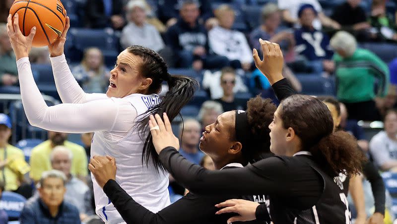 BYU Cougars forward Lauren Gustin (12) reaches for a pass in front of Rice Owls forwards India Bellamy (12) and Ashlee Austin (22) during a Women’s National Invitation Tournament basketball game at the Marriott Center in Provo on Friday, March 17, 2023. BYU lost 71-67.