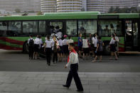 <p>A schoolboy walks toward a carpark as a group of women board a bus in front residential buildings, July 25, 2017, in Pyongyang, North Korea. (Photo: Wong Maye-E/AP) </p>