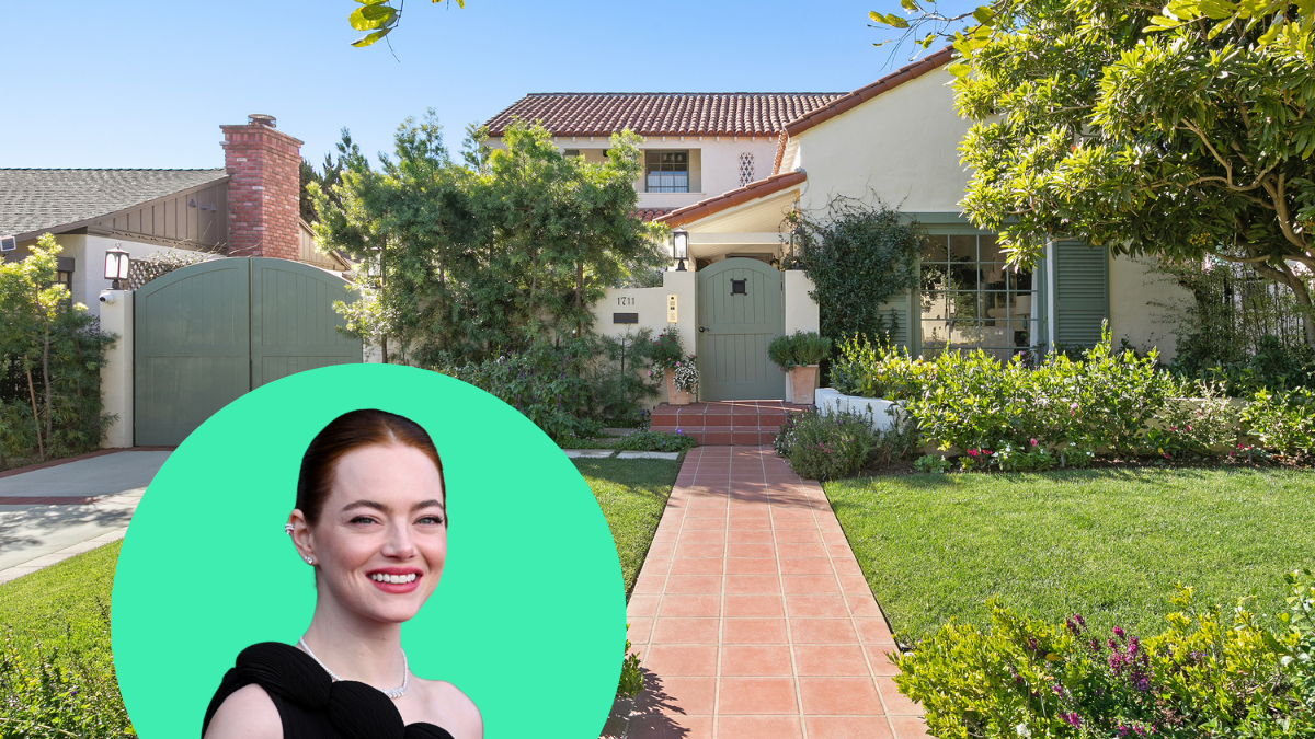 a person smiling with a green helmet in front of a house