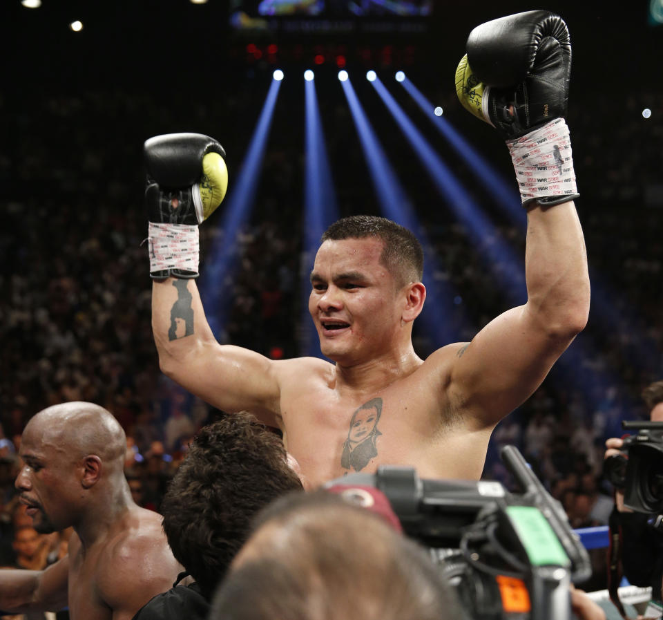 Marcos Maidana, from Argentina, celebrates at the end of his WBC-WBA welterweight title boxing fight against Floyd Mayweather Jr., lower left, Saturday, May 3, 2014, in Las Vegas. Mayweather won the bout by majority decision. (AP Photo/Eric Jamison)