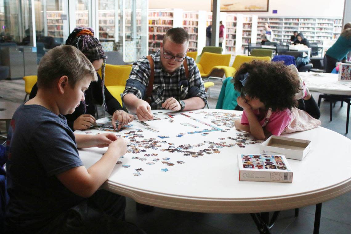 Axel Whitthar, 10, Jordin Dedrick, Kobe Whitthar and Eliya Cano, 7, work together on a puzzle during the jigsaw competition at Indian Creek Library Feb. 4.