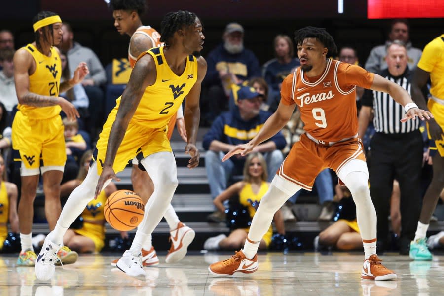 West Virginia guard Kobe Johnson (2) is defended by Texas guard Ithiel Horton (9) during the first half of an NCAA college basketball game on Saturday, Jan. 13, 2024, in Morgantown, W.Va. (AP Photo/Kathleen Batten)