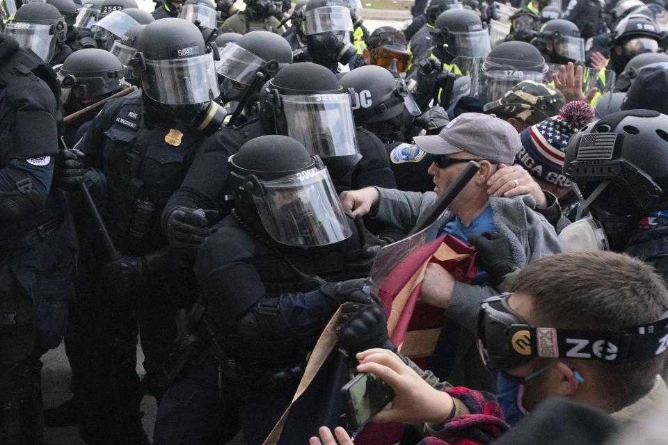 Capitol police officers in riot gear push back demonstrators trying to break a door of the U.S. Capitol on Jan. 6, 2021, in Washington, D.C.