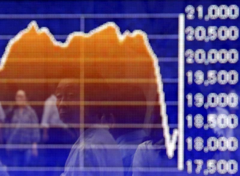 A pedestrian is reflected on an electronic board showing the graph of the recent fluctuations of the Japan's Nikkei average outside a brokerage in Tokyo, Japan, August 27, 2015. REUTERS/Yuya Shino