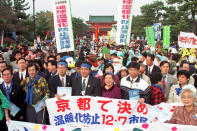 FILE - Environmentalists and citizens hold banners calling for reduction of green house gas emissions in front of the Heian shrine in Kyoto, western Japan on Dec. 7, 1997. (AP Photo/Katsumi Kasahara, File)