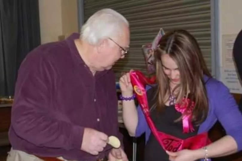 Amy on the right wearing a birthday sash and her grandad on left