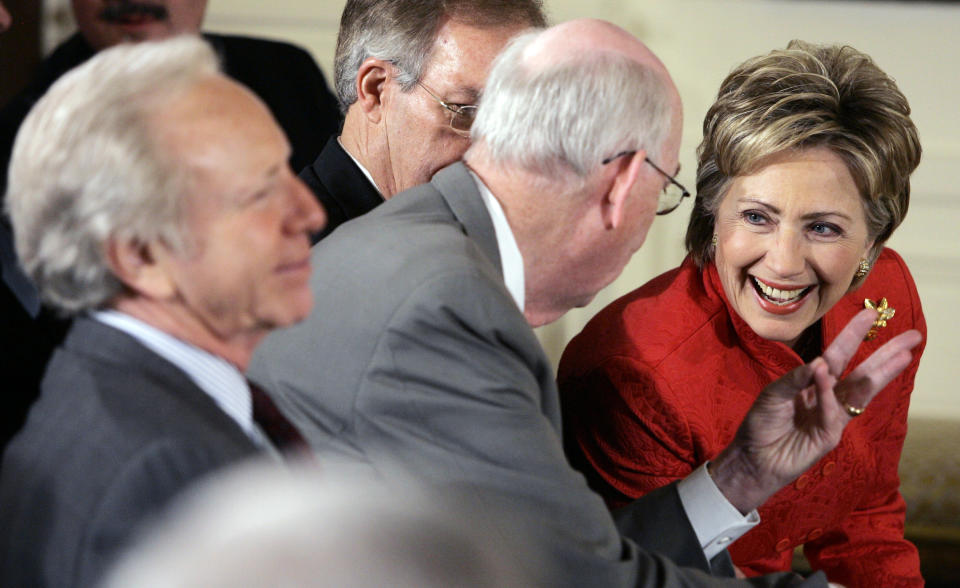 FILE - Democratic presidential hopeful Sen. Hillary Clinton, right, talks with Sen. Robert Bennett, R-Utah, second from left, as Sen. Joseph Lieberman, I-Conn., left, and Sen. Wayne Allard, R-Colo., obscured, looks on prior to President George W. Bush, not shown, spoke during the National Day of Prayer event, May 3, 2007, in the East Room of the White House in Washington. (AP Photo/Charles Dharapak, File)
