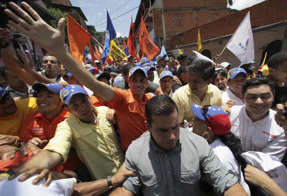 Opposition's presidential candidate Henrique Capriles, center, greets supporters during a campaign rally in Caracas, Venezuela, Sunday, Sept. 16, 2012. Capriles is running against President Hugo Chavez in the country's Oct. 7 election. (AP Photo/Fernando Llano)