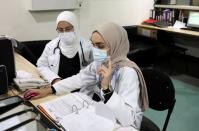 Israa Seblani, a Lebanese doctor and the bride who was caught up in the last year's Beirut port blast during a wedding photoshoot, gestures as she works at Rafik Hariri University Hospital, in Beirut